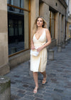 Neutral cream wrap dress styled casually with sneakers and elegantly with heels.